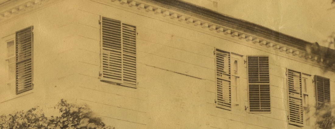 Detail of a photograph of the Morris-Jumel Mansion showing several windows with venetian blinds.